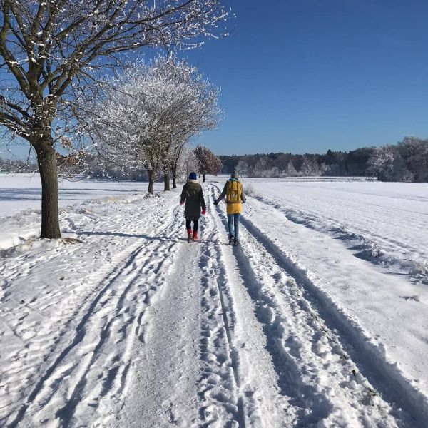 Ein Pärchen bei einem Spaziergang in einer schneebedeckten Landschaft